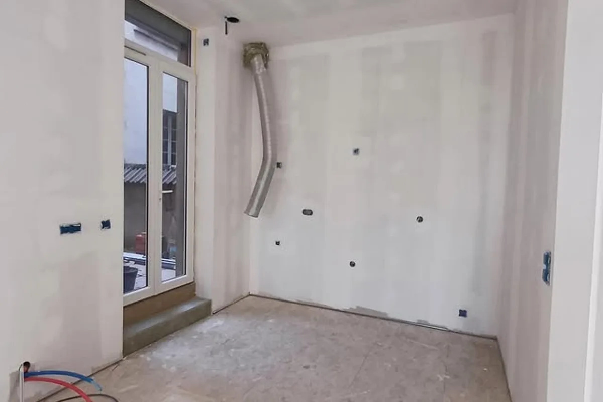Avant : Pièce brute en placo avec attentes plomberie et électricité avant pose de la cuisine, région de Vienne