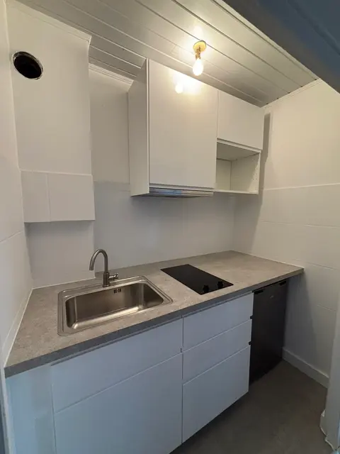 Kitchenette blanche sur mesure installée sous rampants de combles — HDM Menuiserie