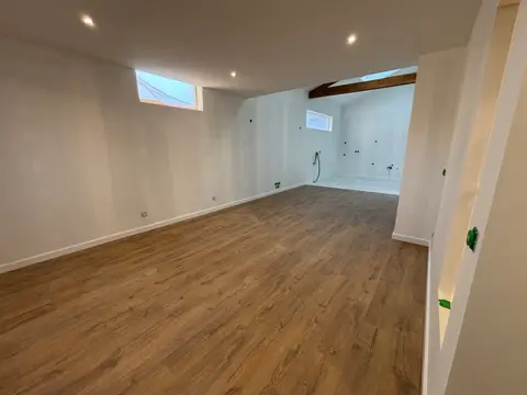 Pièce mansardée rénovée avec parquet bois moyen, skylight et spots LED — HDM Menuiserie